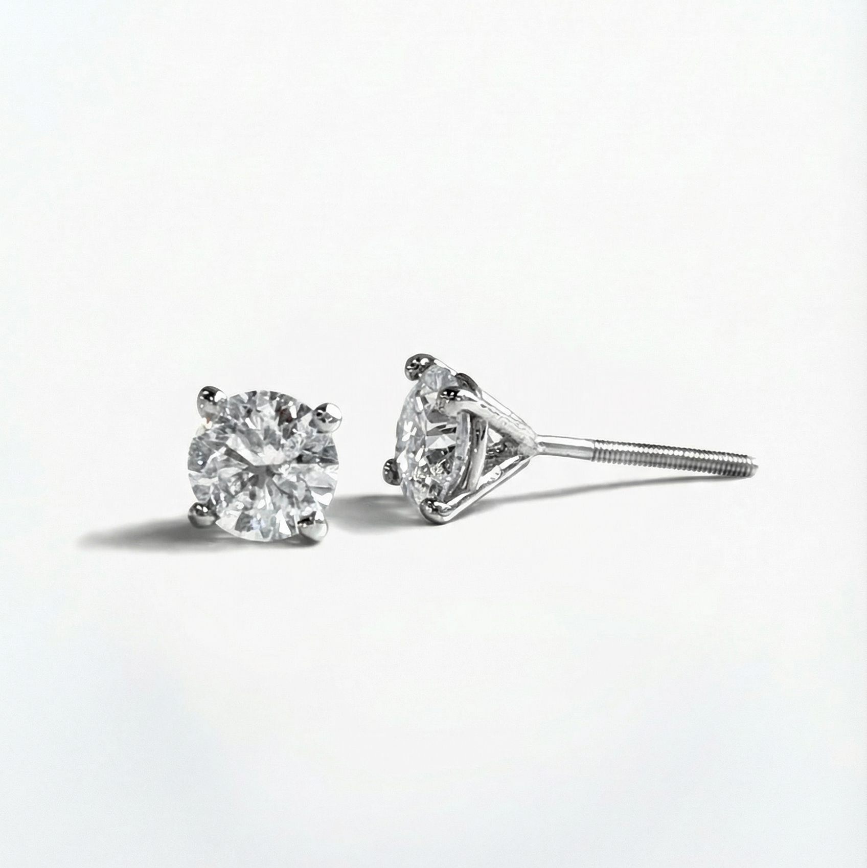 Pair of diamond stud earrings on a white background