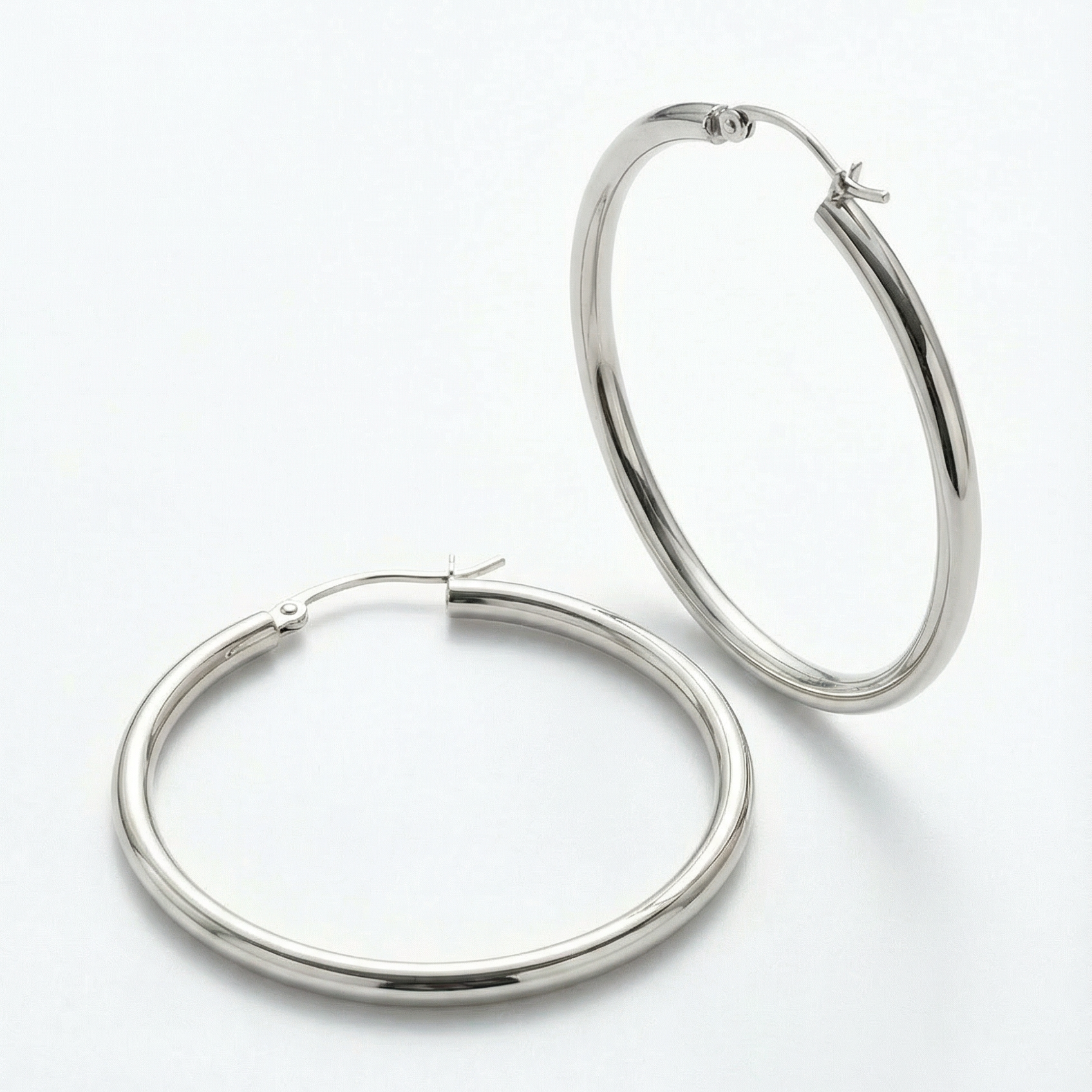 Pair of white gold hoops on white background