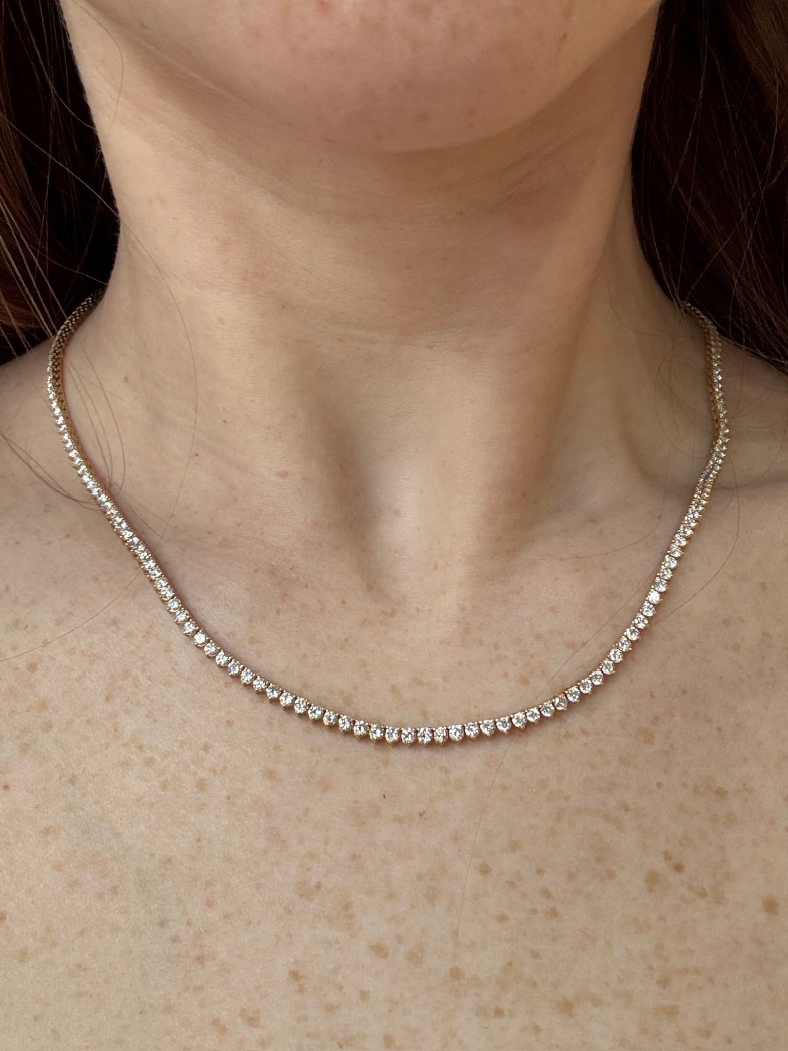 Necklace with small stones on a person's neck
